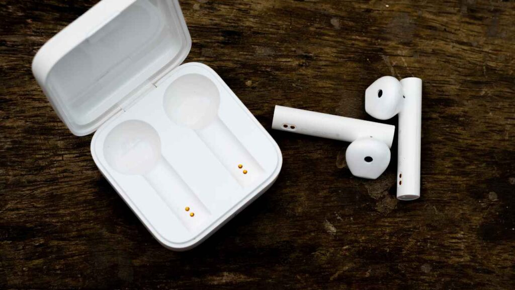 white colored earbuds with case on table