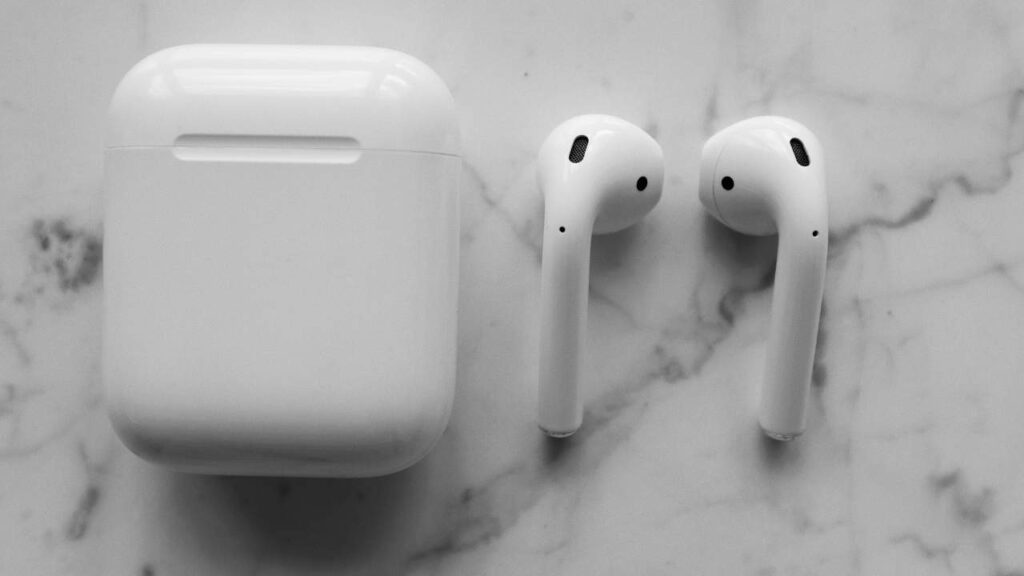 white colored earbuds with case on the table